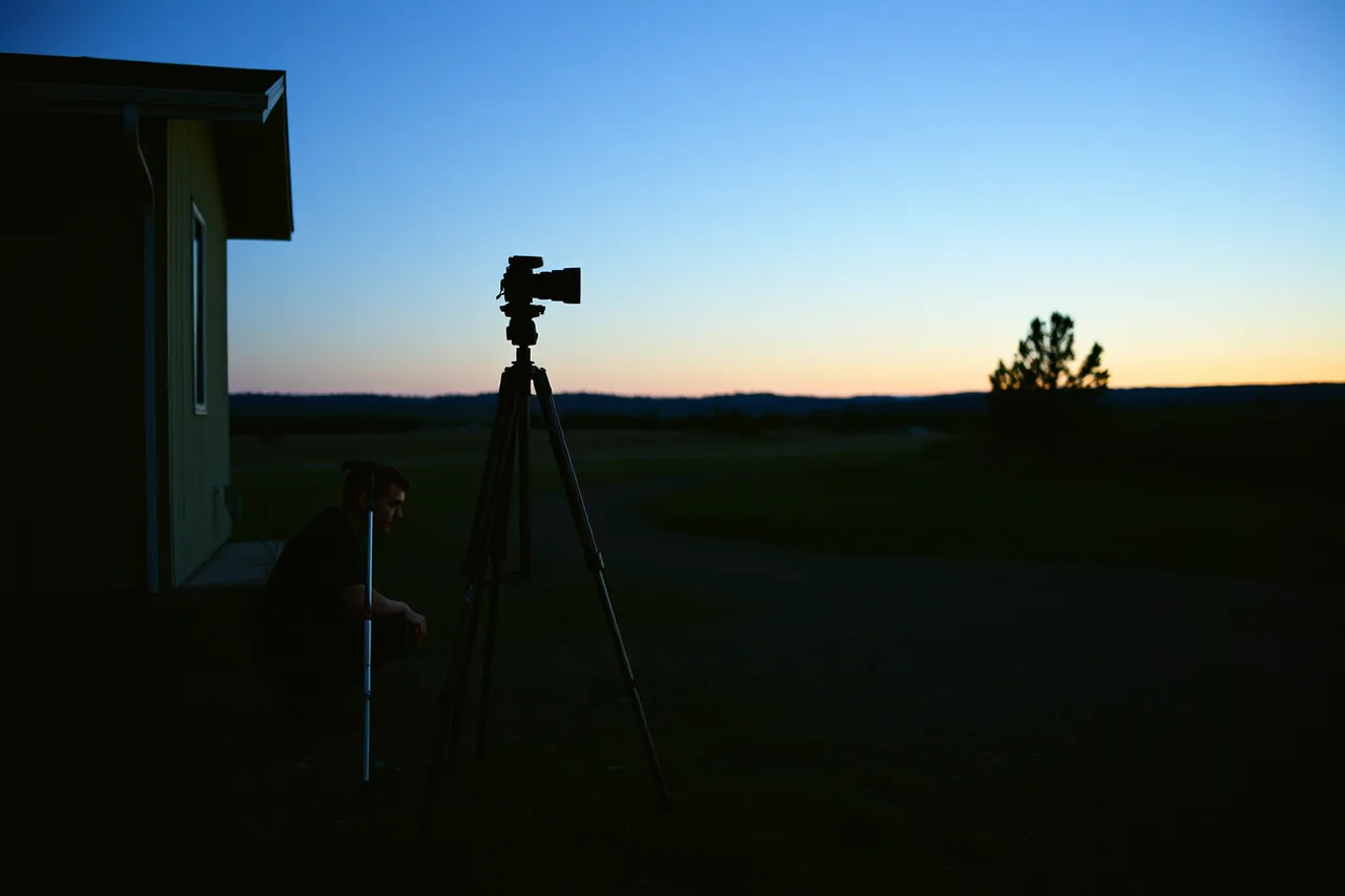 Tripod set up on level ground at a property's darkest corner before sunset (Reading dark sky lodging field: ask first, based on documented cases)