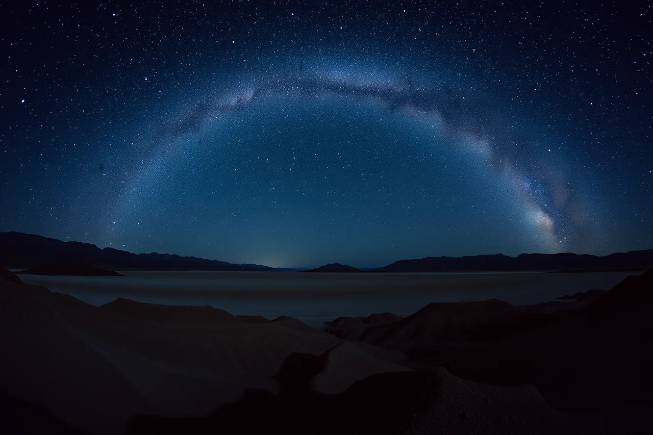 Milky Way arching over dark Death Valley desert basin (How to plan a stargazing road trip from Los Angeles to Death Valley)